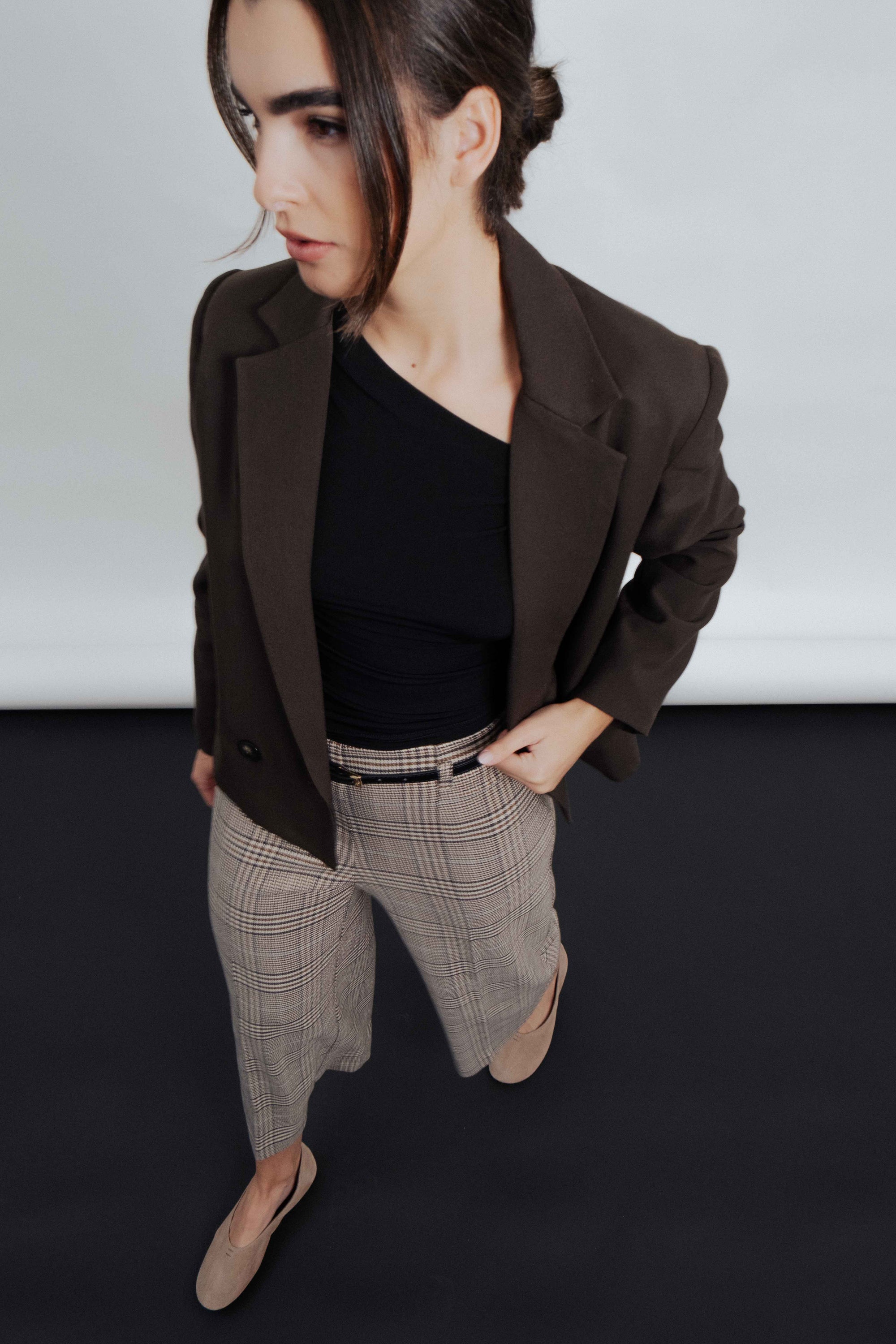 Vue plongeante d'une femme en Pantalon culotte à carreaux marron, portant une veste, mettant en avant une allure chic.