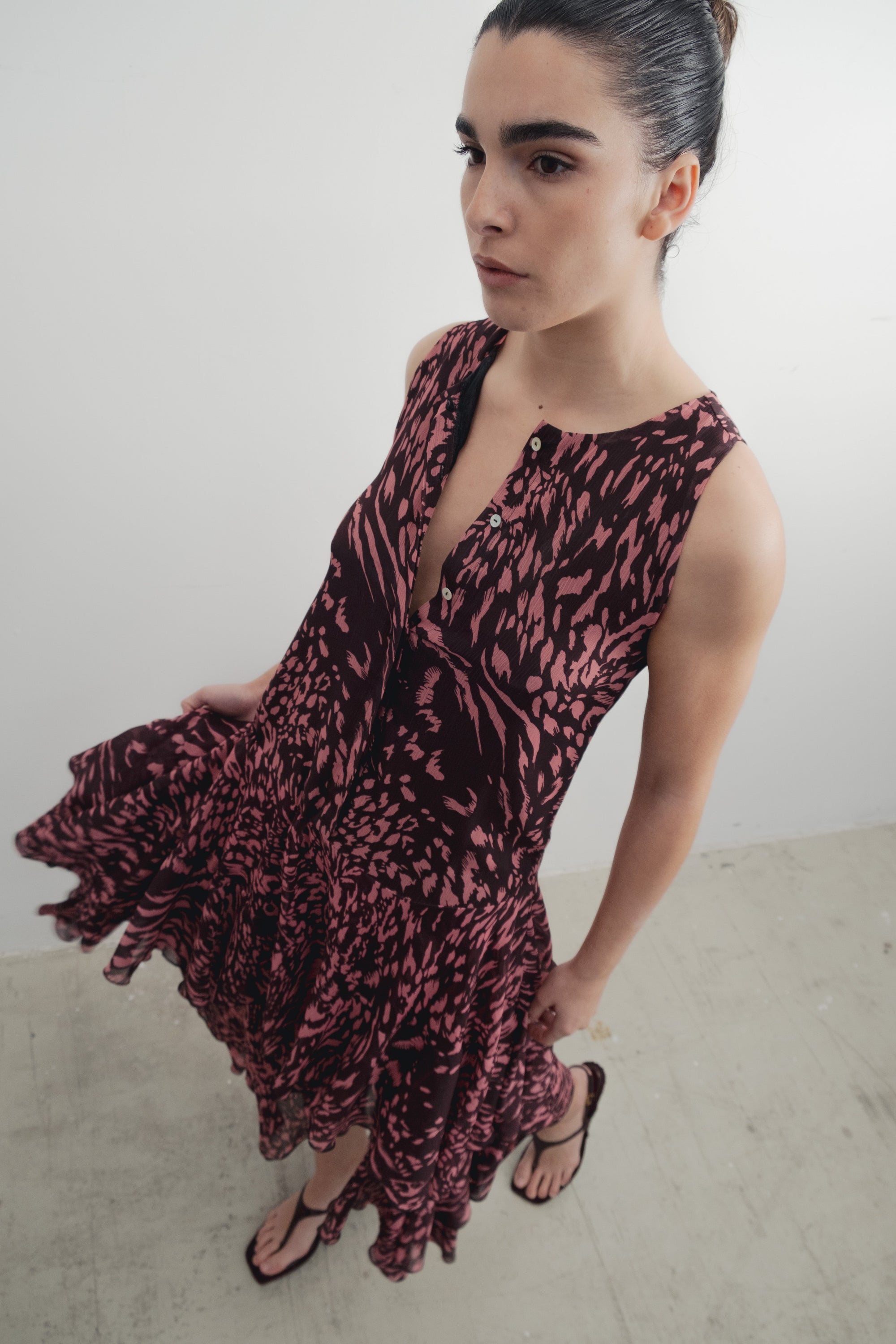 Robe longue imprimée à volants sans manches marron, modèle féminin, vue dynamique mettant en avant le mouvement du tissu.