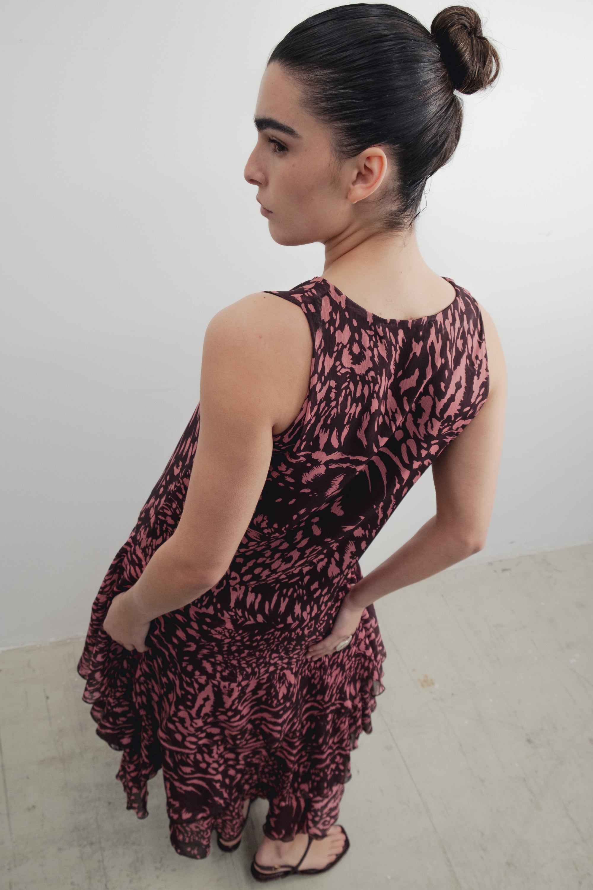 Robe longue imprimée à volants sans manches marron, modèle féminin en marche, ambiance décontractée.