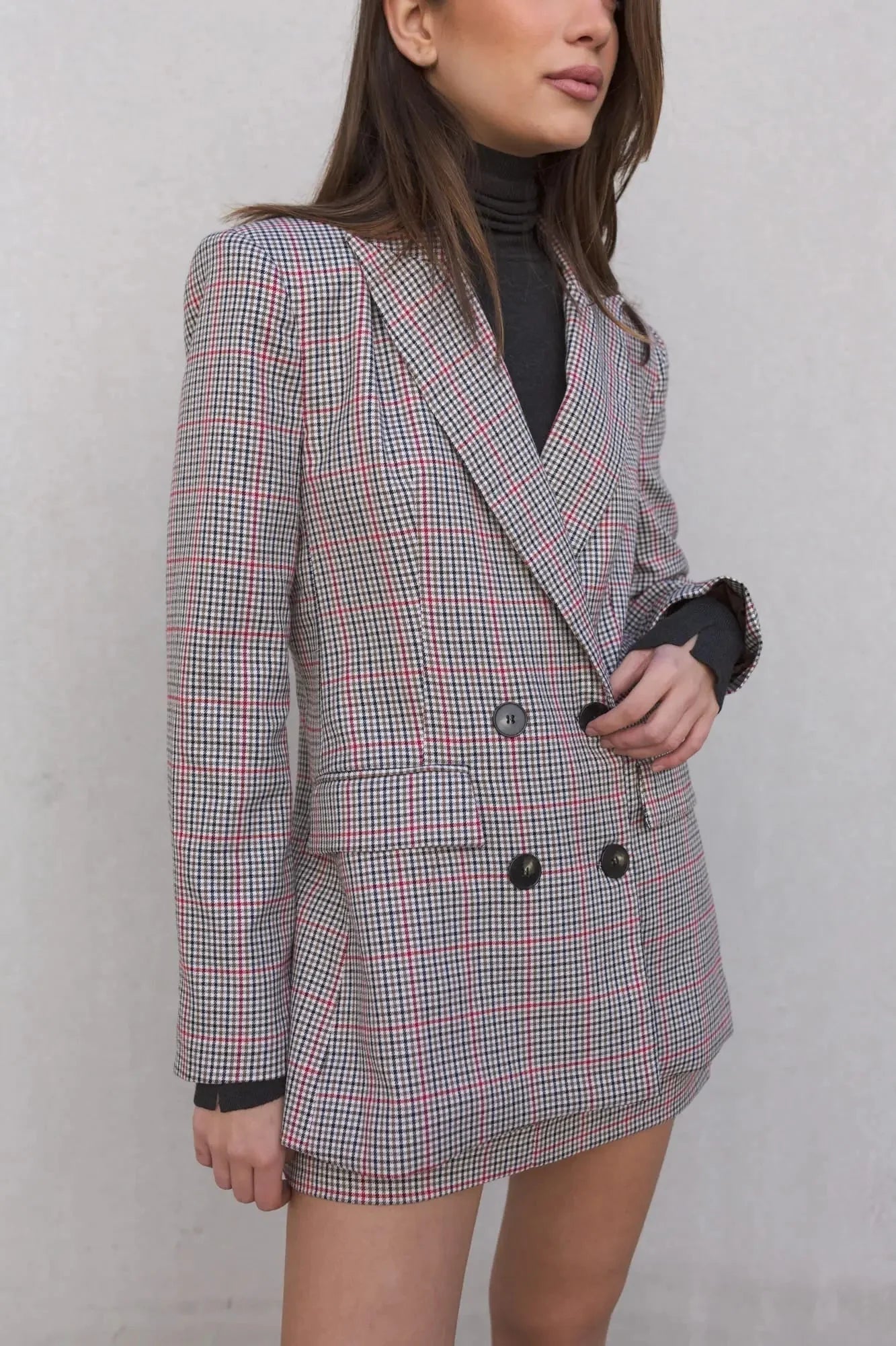 Détail d'un modèle portant le blazer femme double boutonnage à carreaux avec une mini jupe élégante de Sapiato, mettant en valeur la texture.