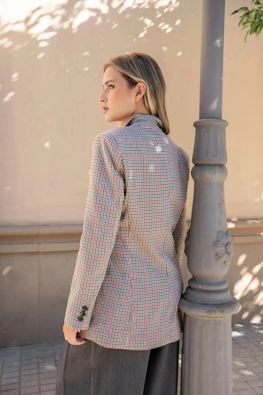 Modèle avec le blazer femme double boutonnage, posant avec un look élégant, associé à un pantalon large.