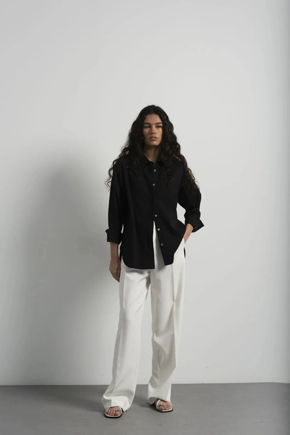 Femme portant un pantalon plissé blanc et un blazer assorti, look élégant et chic