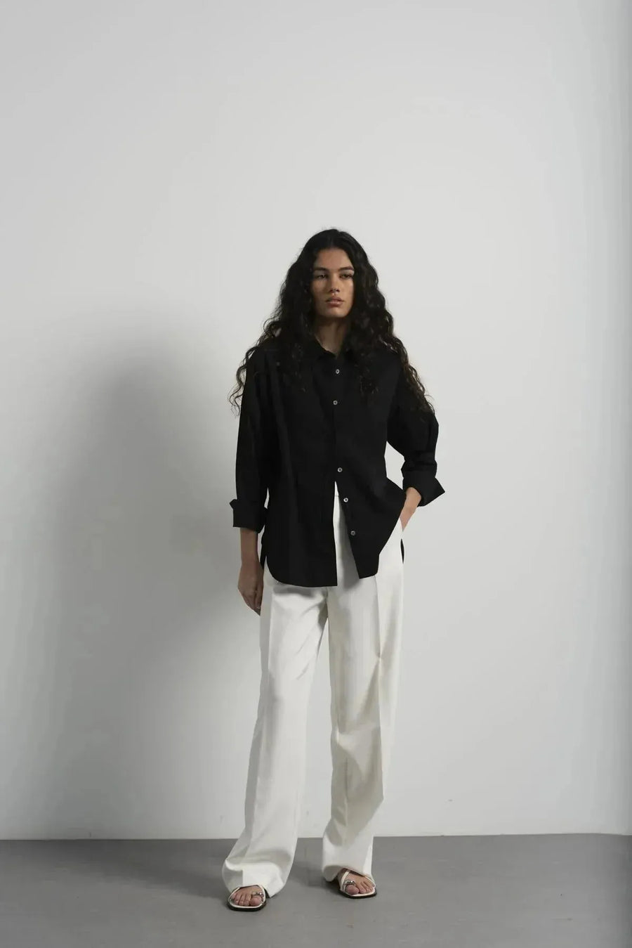 Femme portant un pantalon plissé blanc et un blazer assorti, look élégant et chic