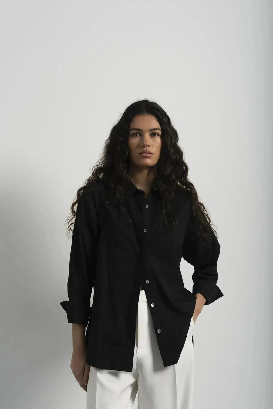 Person portant un ensemble blazer et pantalon plissé blanc pour un look élégant