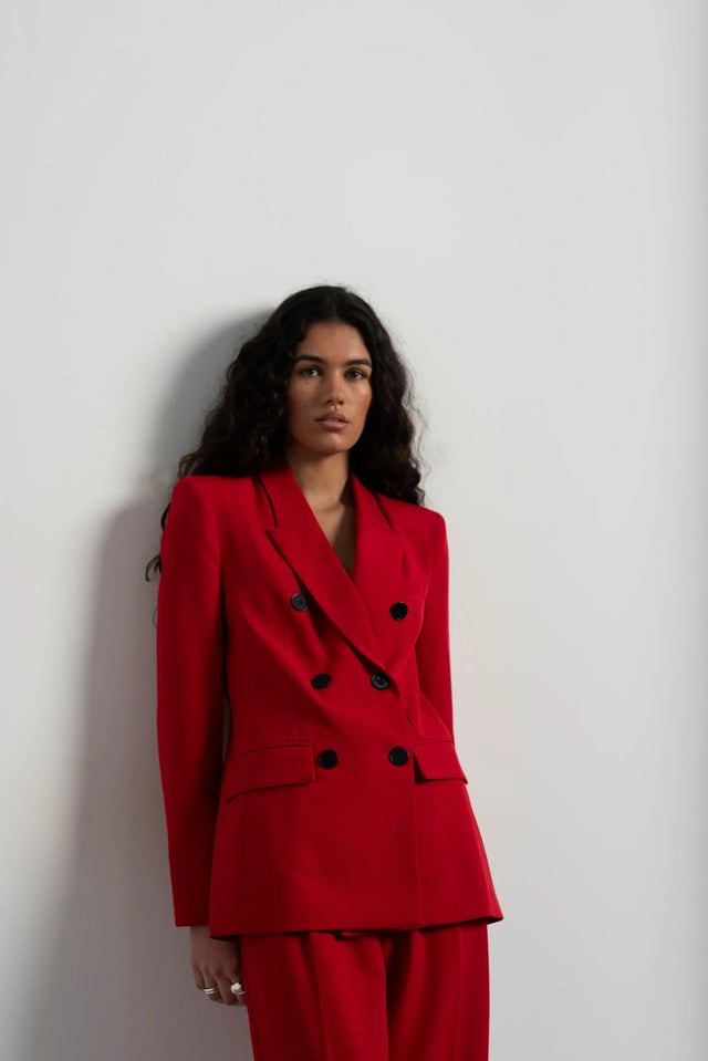Zoom sur l'ensemble blazer oversize rouge et pantalon large, avec un style raffiné de blazer femme rouge, parfait pour un look chic et moderne.