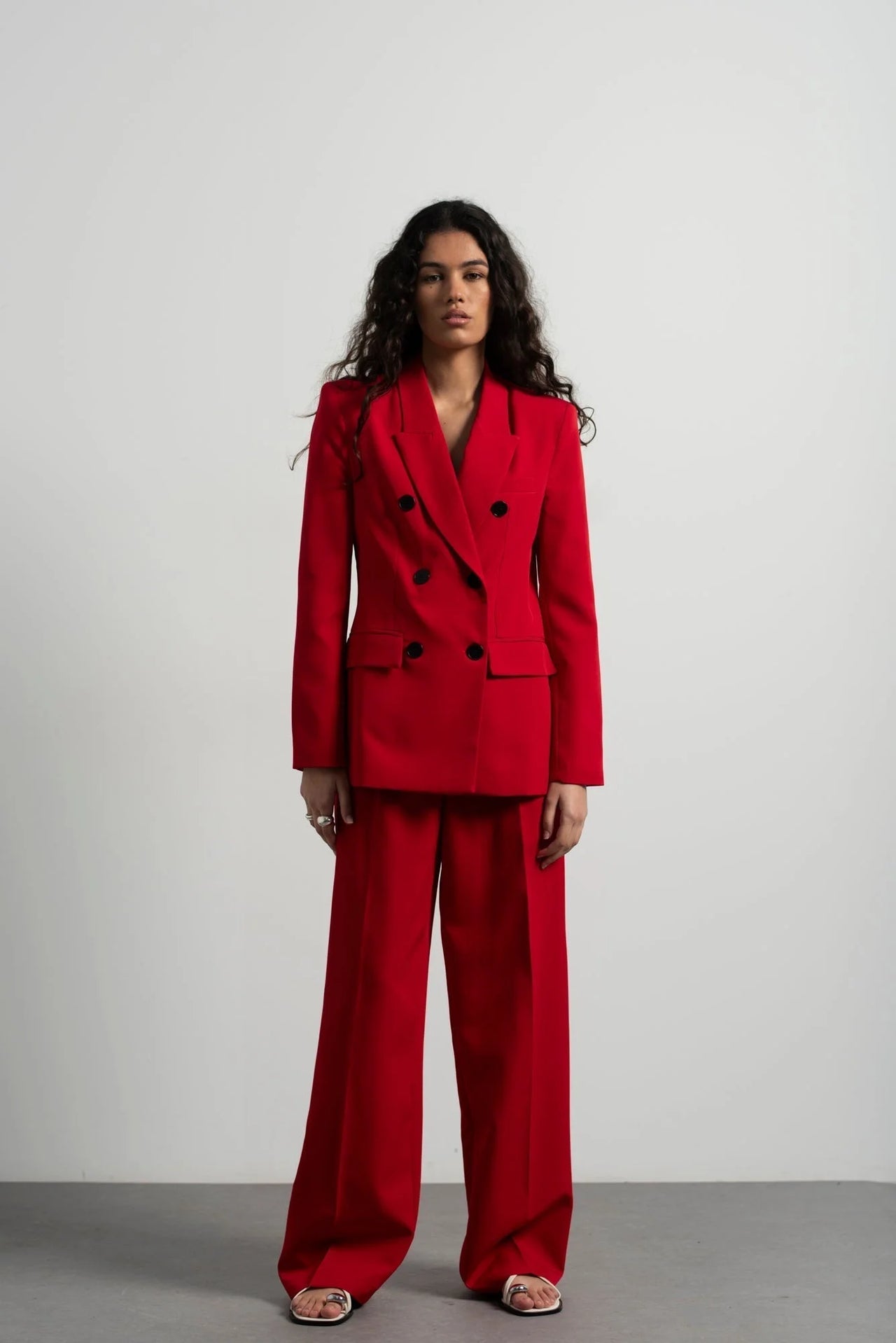 Ensemble blazer oversize rouge et pantalon large, mettant en avant un blazer femme rouge élégant porté par une modèle. Idéal pour des occasions formelles ou décontractées.