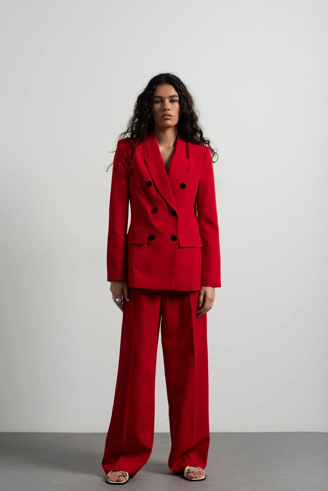 Ensemble blazer oversize rouge et pantalon large, mettant en avant un blazer femme rouge élégant porté par une modèle. Idéal pour des occasions formelles ou décontractées.