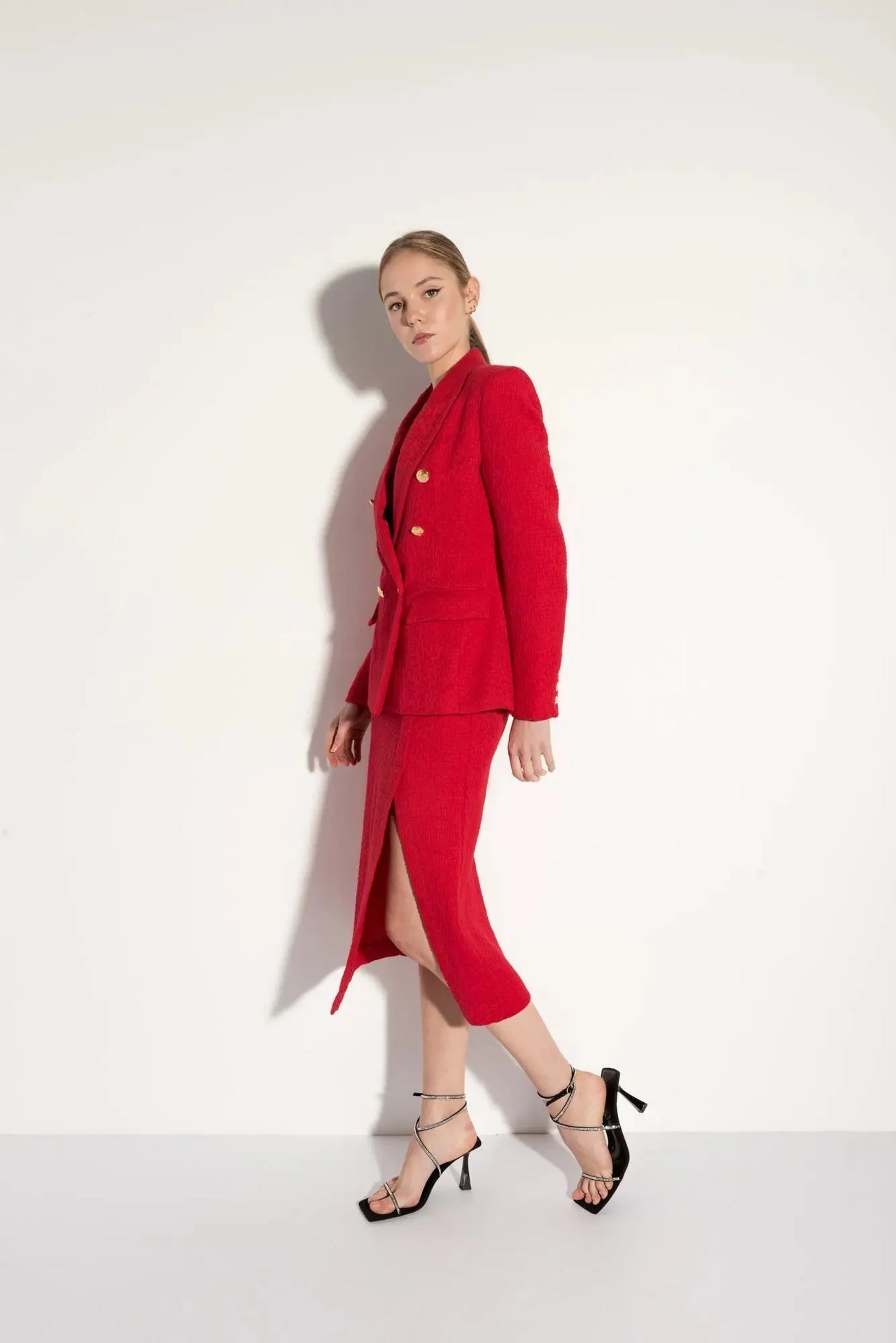 Blazer chic femme texturé rouge porté avec élégance, mettant en avant son design sophistiqué et moderne.