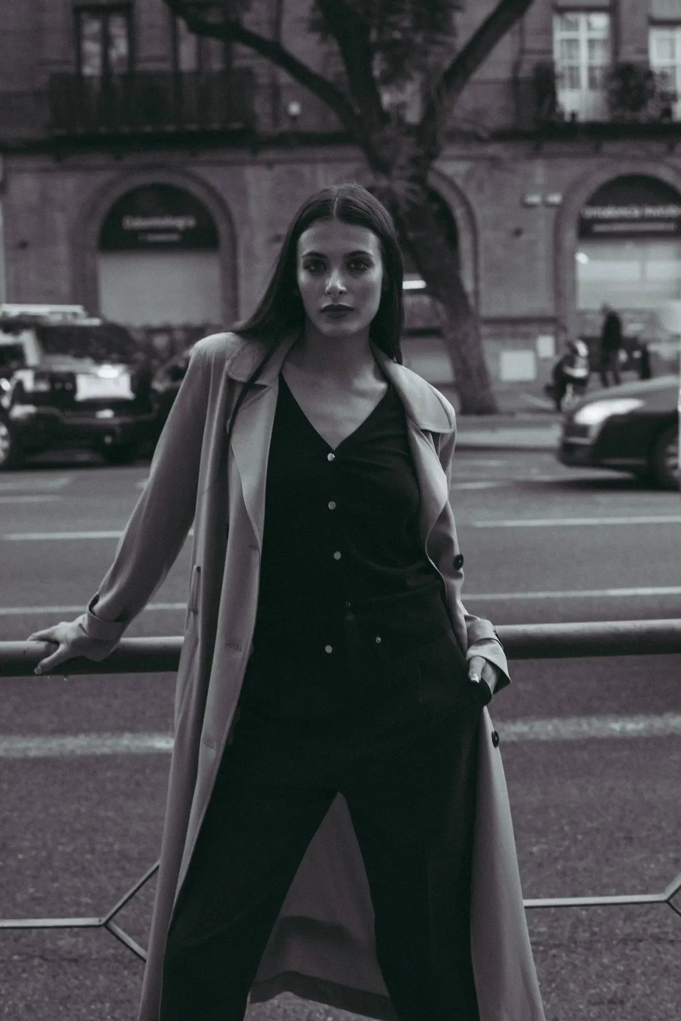 Femme en trench long et jumpsuit sombre portant un ensemble cardigan tricoté et pantalon large camel