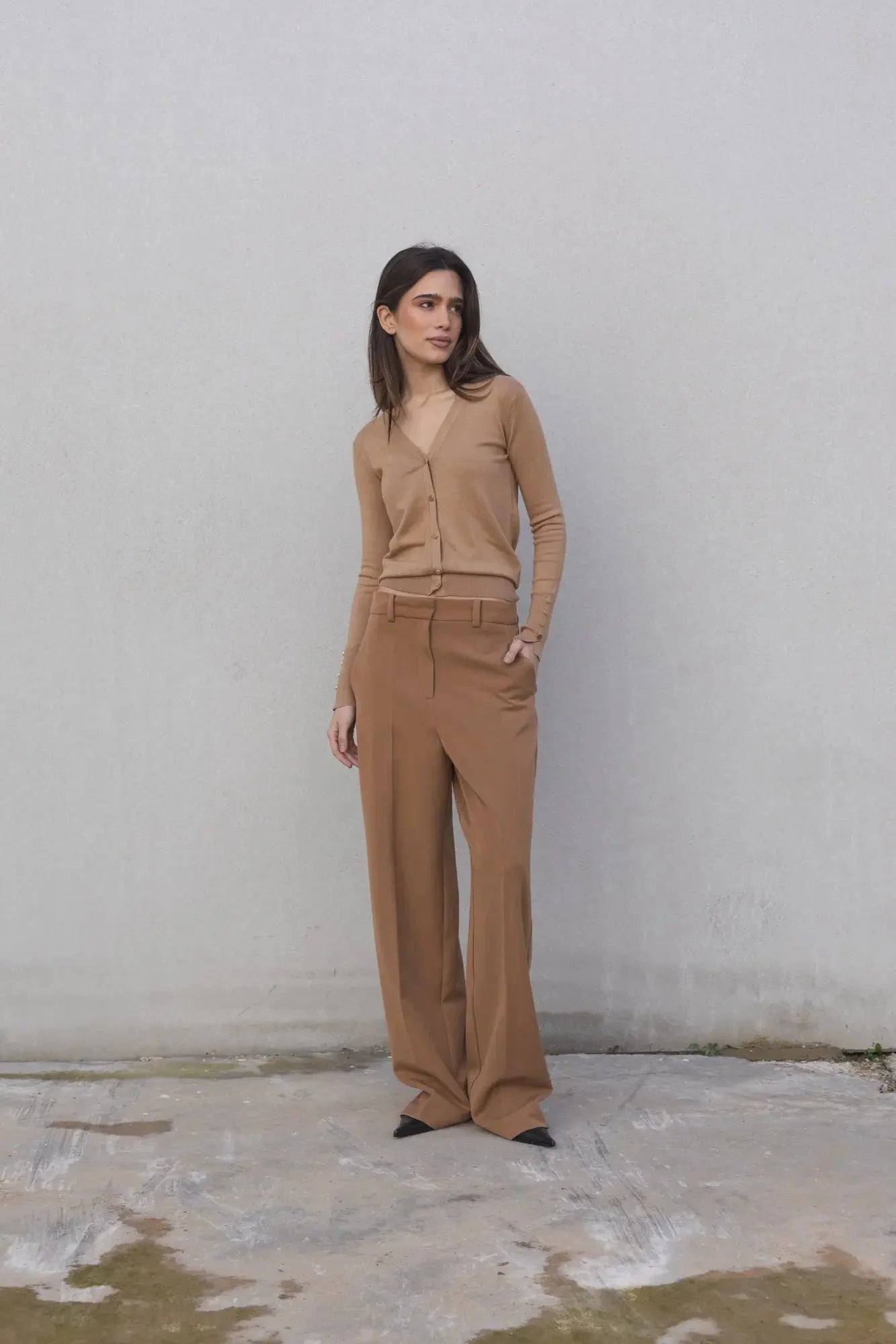 Ensemble cardigan tricoté et pantalon large camel porté par une femme en tenue élégante