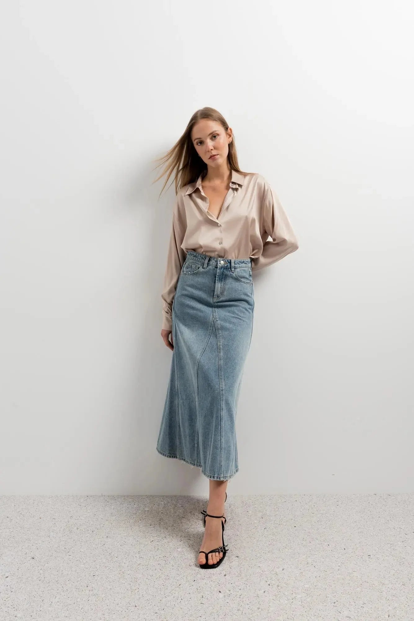 Modèle portant une chemise en satin femme élégante avec une jupe en jean, idéale pour toutes les occasions.