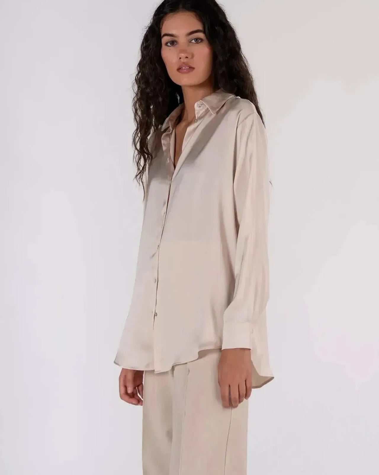 Détails d'une femme en chemise en satin femme, affichant un style décontracté avec une touche d'élégance.