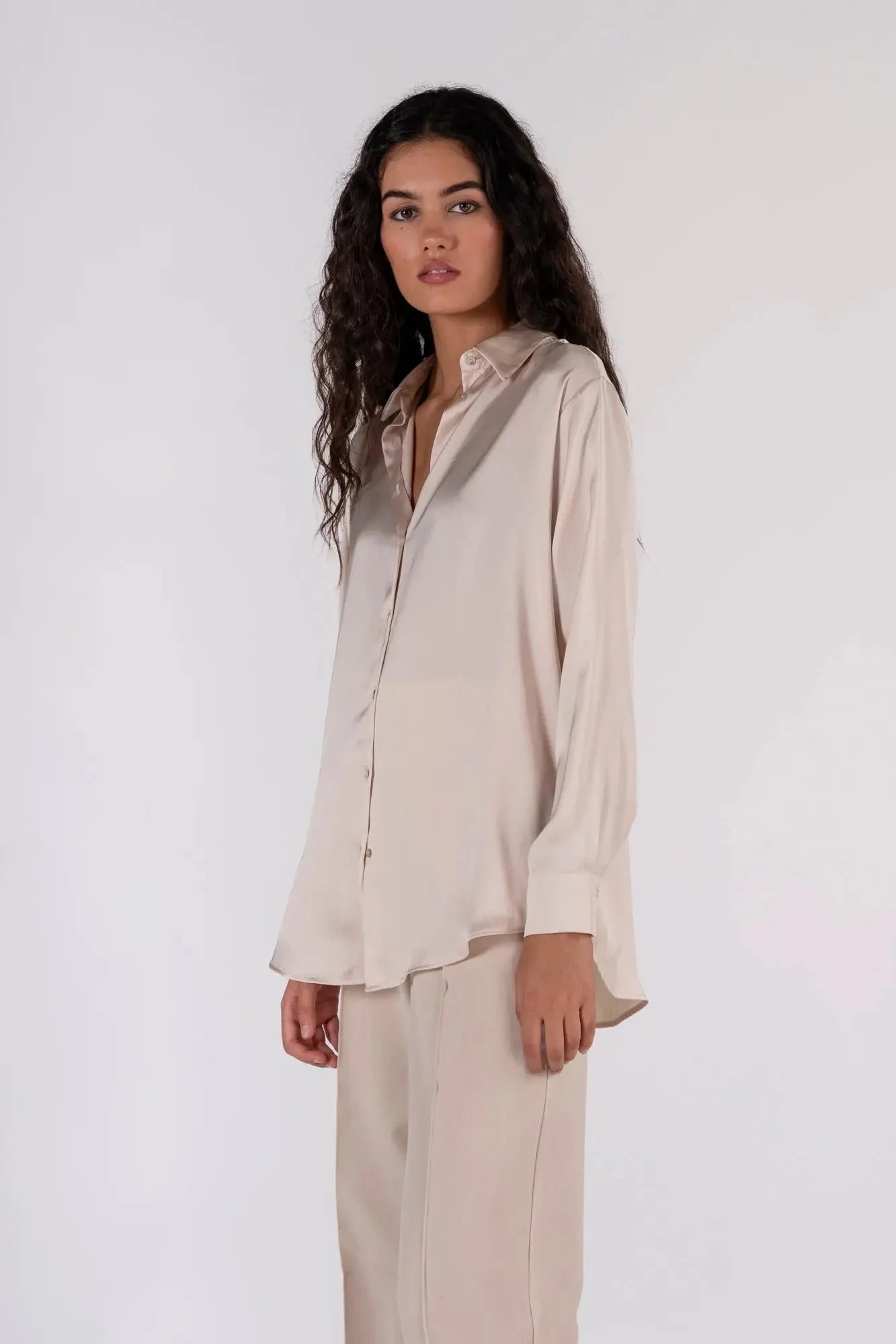 Détails d'une femme en chemise en satin femme, affichant un style décontracté avec une touche d'élégance.