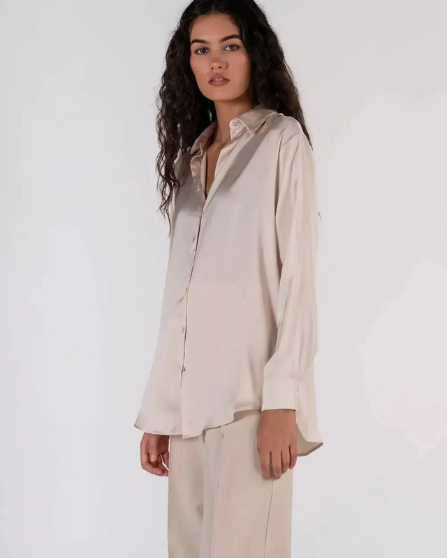 Détails d'une femme en chemise en satin femme, affichant un style décontracté avec une touche d'élégance.