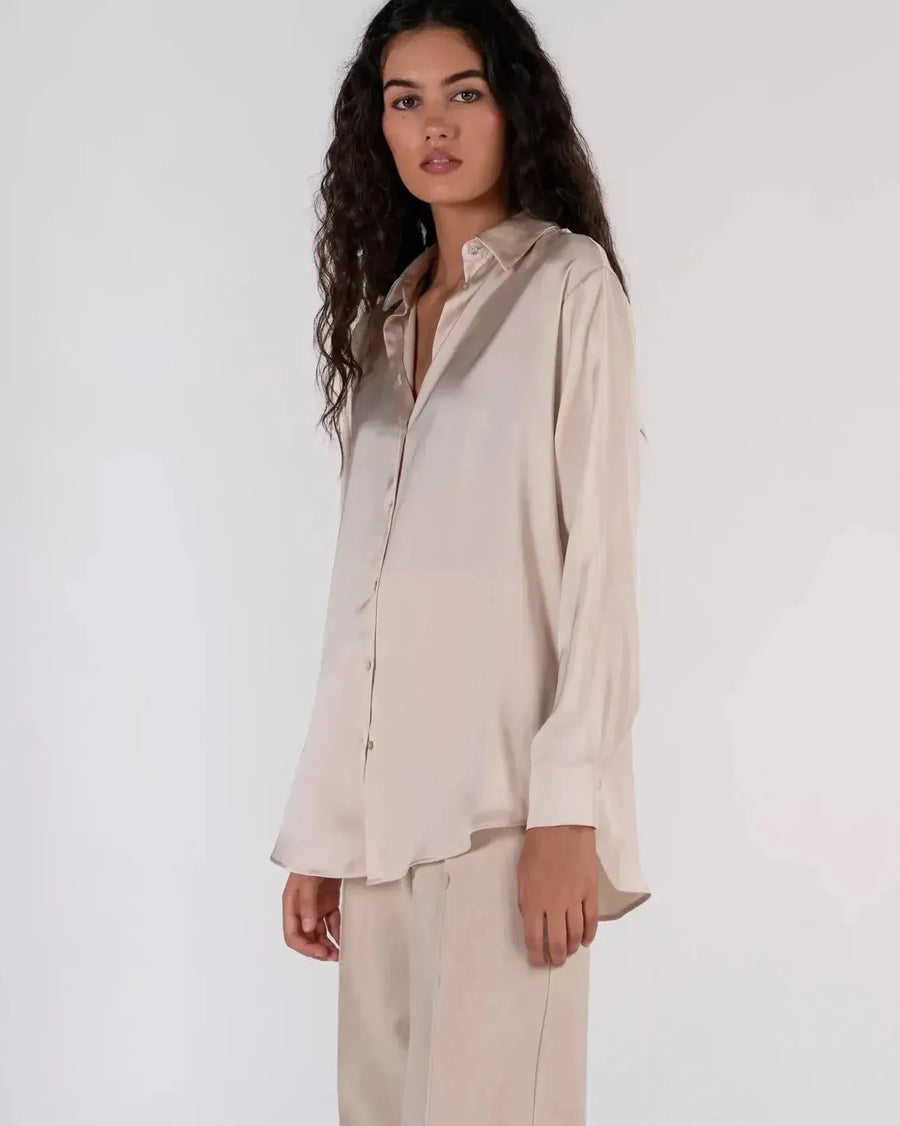 Détails d'une femme en chemise en satin femme, affichant un style décontracté avec une touche d'élégance.