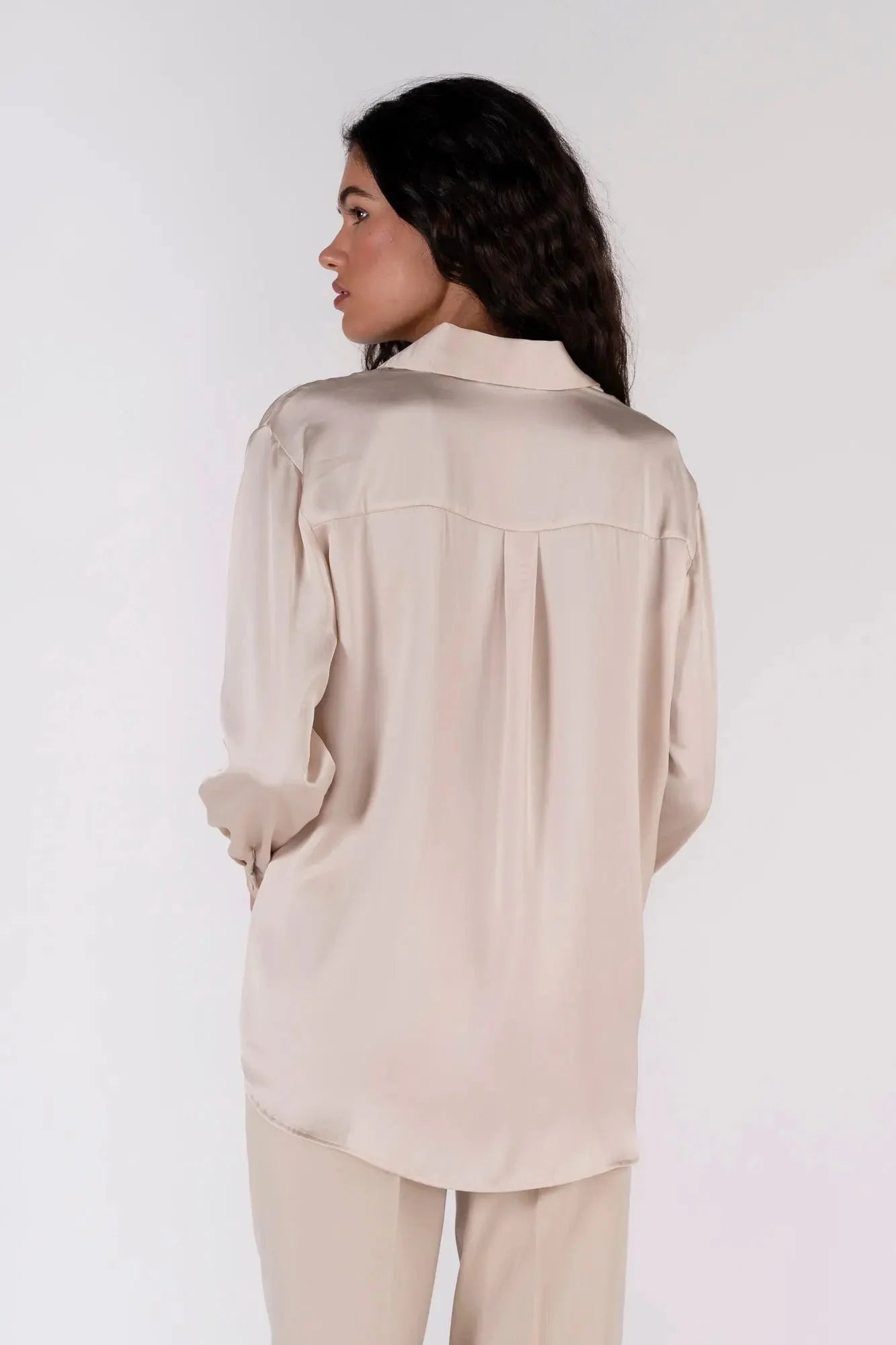 Vue arrière d'une femme en chemise en satin femme, montrant le design fluide et stylé.