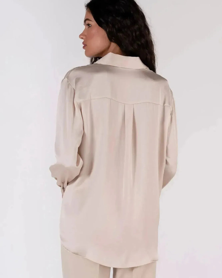 Vue arrière d'une femme en chemise en satin femme, montrant le design fluide et stylé.