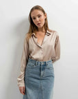 Gros plan sur une femme en chemise en satin femme, chic et confortable, parfaite pour un look décontracté.
