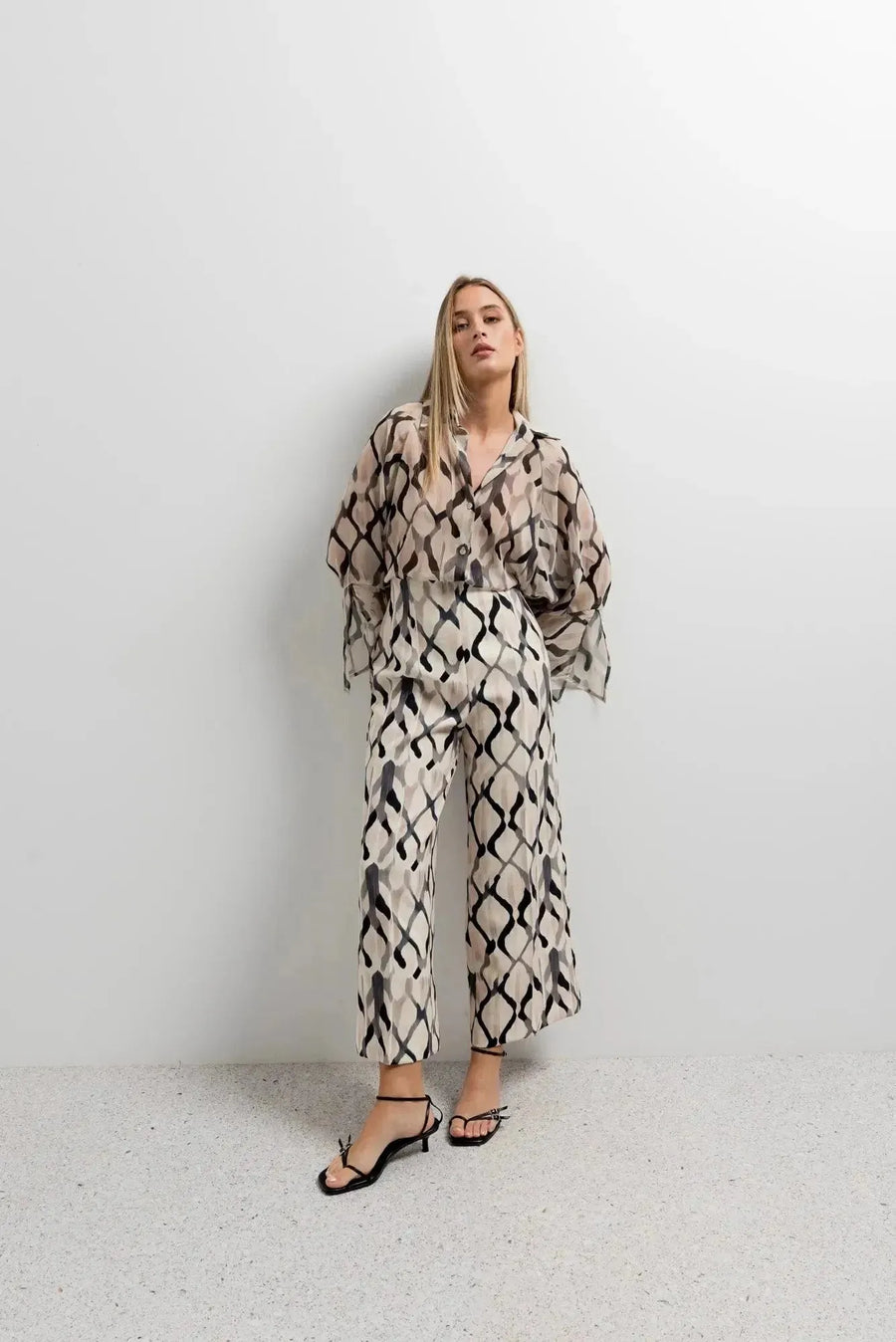 Femme portant un ensemble chemise et pantalon imprimée culotte, mettant en avant le pantalon culotte femme avec un motif chic et moderne.