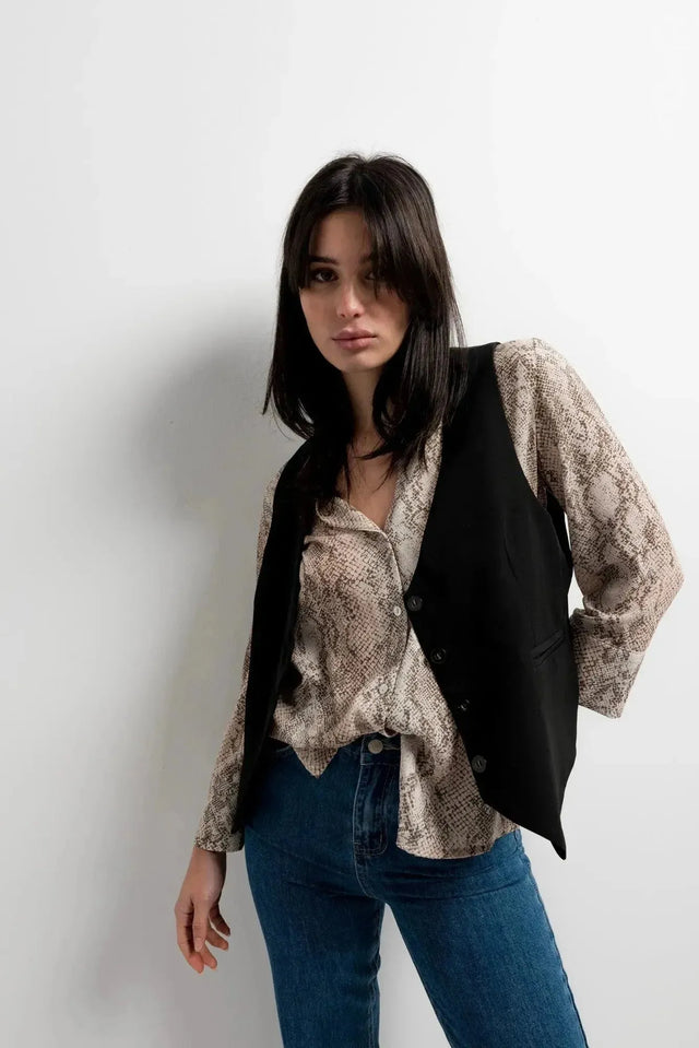Modèle avec une chemise imprimée animal femme et gilet noir, affichant une allure moderne et tendance.