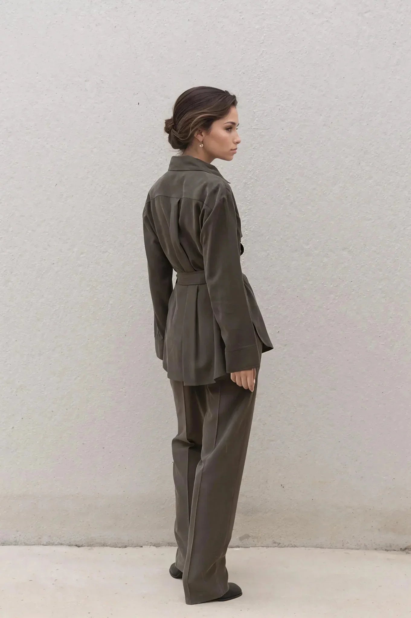 Femme portant un ensemble coordonné chemise et pantalon vert olive sombre avec ceinture
