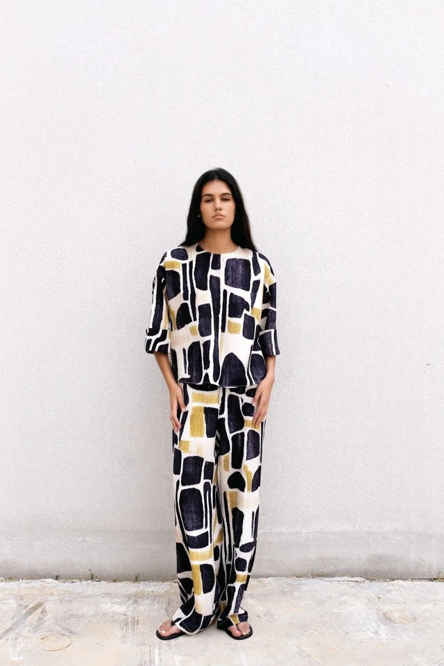 Modèle en Blouse Tendance Femme Sapiato, démontrant la féminité et l'élégance dans une atmosphère contemporaine.