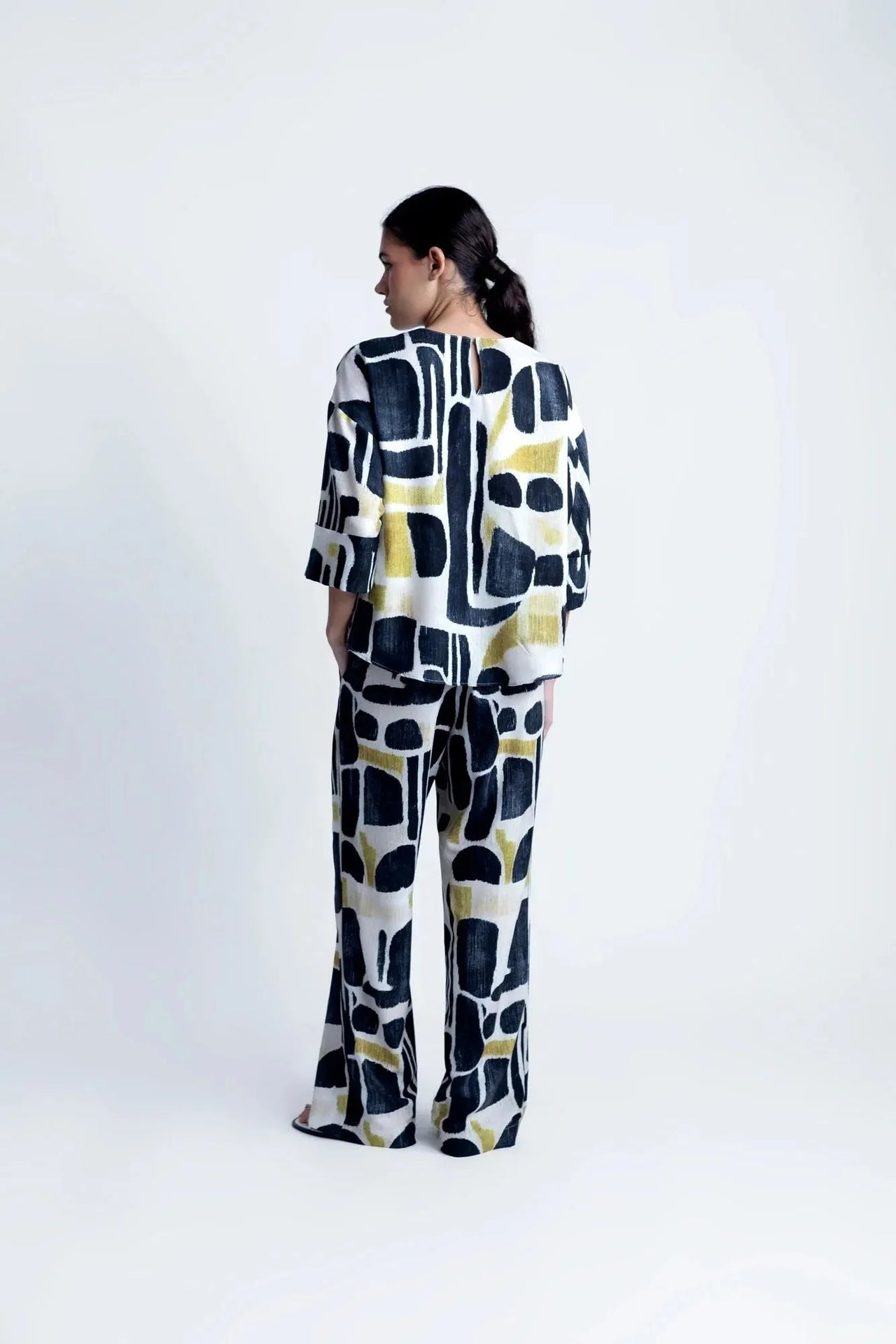 Femme stylée dans la Blouse Tendance Femme Sapiato, présentant un look moderne avec des accessoires.