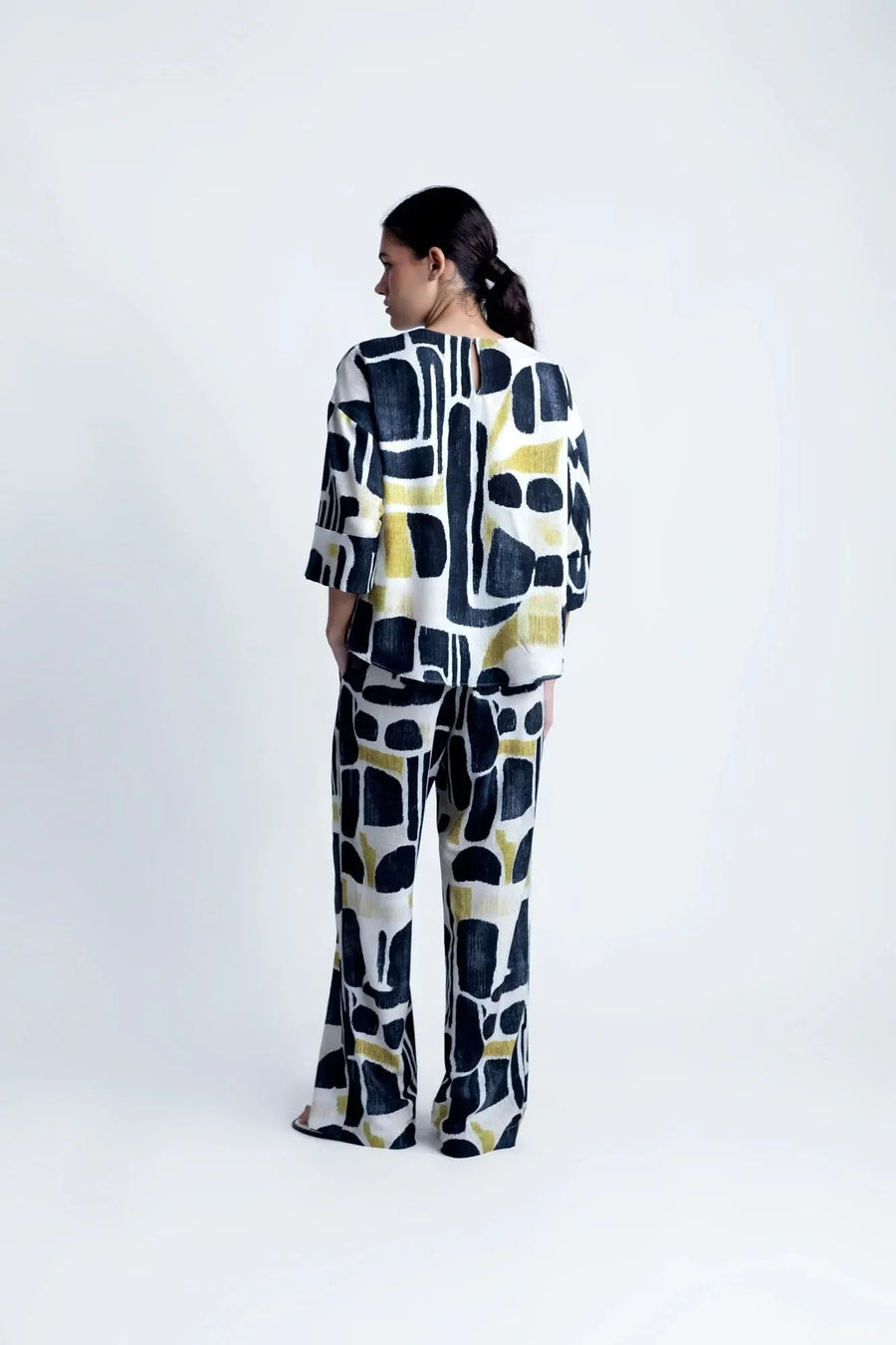 Femme stylée dans la Blouse Tendance Femme Sapiato, présentant un look moderne avec des accessoires.