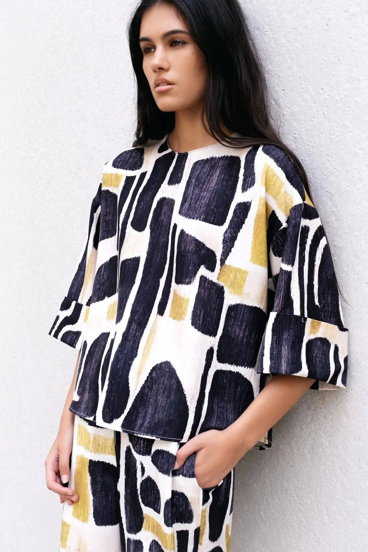 Modèle portant la Blouse Tendance Femme Sapiato dans un design moderne et unique, associée à une ambiance élégante.