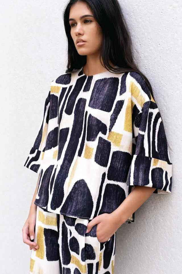 Modèle portant la Blouse Tendance Femme Sapiato dans un design moderne et unique, associée à une ambiance élégante.