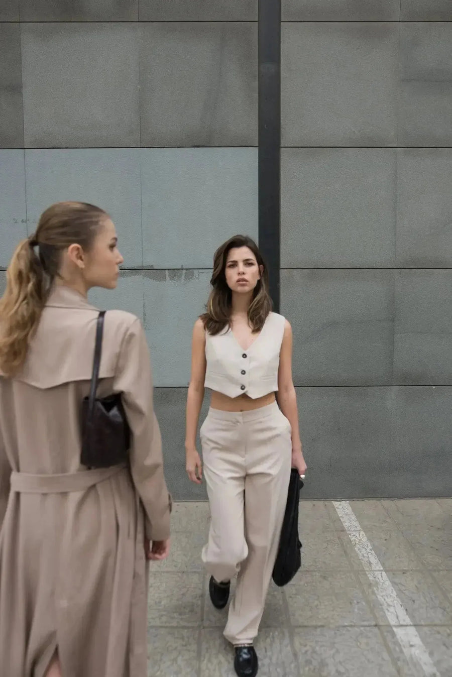 Femme portant un gilet de costume femme court beige élégant et confortable, marchant avec assurance dans un cadre urbain. Idéal pour toutes occasions.