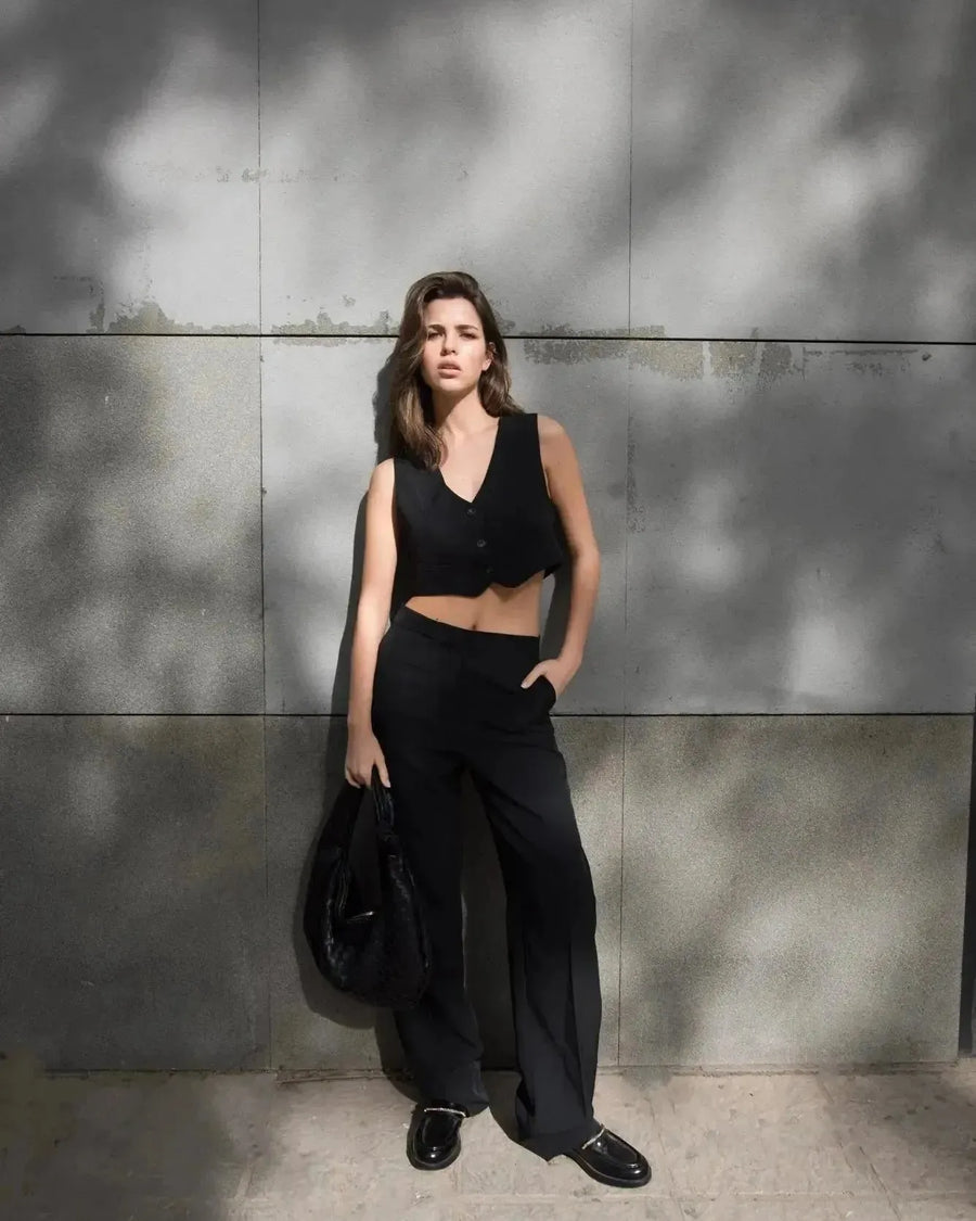 Modèle dans un gilet costume femme court, sortant avec un look monochrome élégant et moderne.