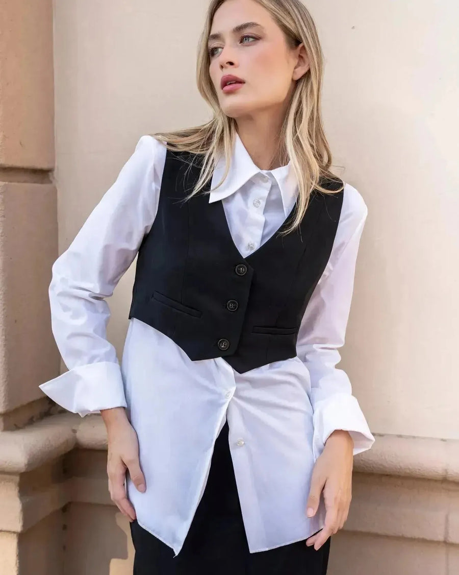 Modèle présentant un gilet costume femme court superposé sur une chemise blanche, pour un look casual.