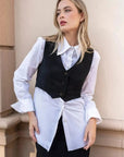 Modèle présentant un gilet costume femme court superposé sur une chemise blanche, pour un look casual.
