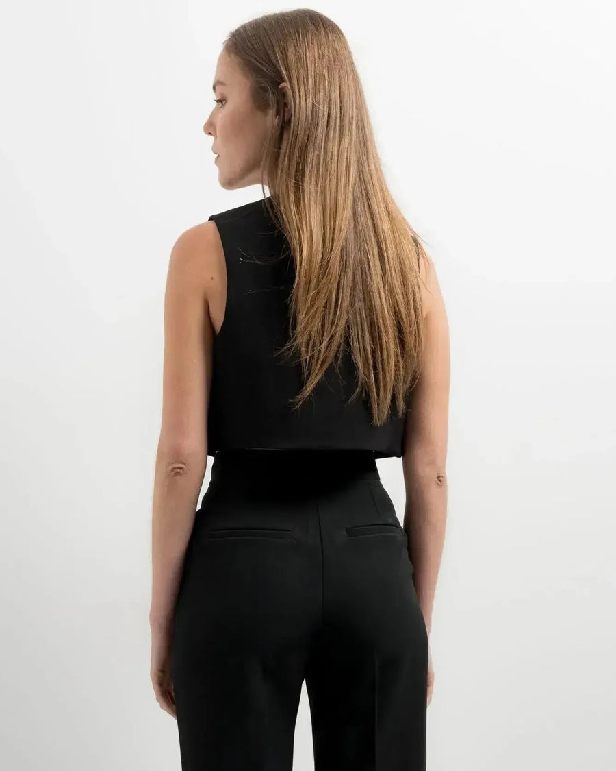Modèle posant avec assurance dans un gilet costume femme court, parfaite pour une tenue élégante.