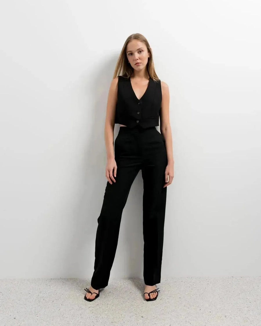 Femme dans un gilet costume femme court, affichant une pose confiante pour un style chic et contemporain.