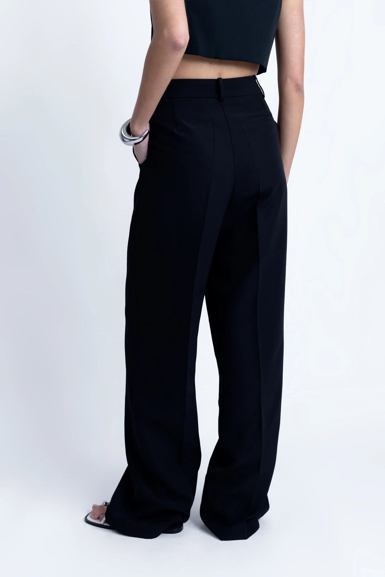 Pantalon Noir Fluide Femme Élégant à Pinces en Polyester Recyclé, présenté avec une vue arrière qui souligne le confort et l'élégance.