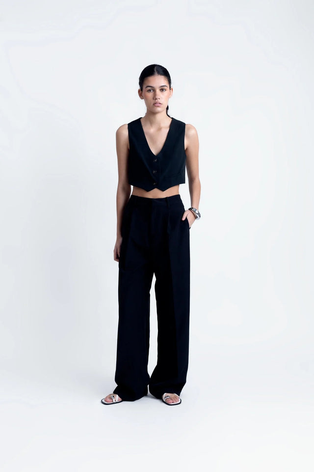 Pantalon Noir Fluide Femme Élégant à Pinces en Polyester Recyclé, modèle présenté debout avec un top court, exhalant style et confort.