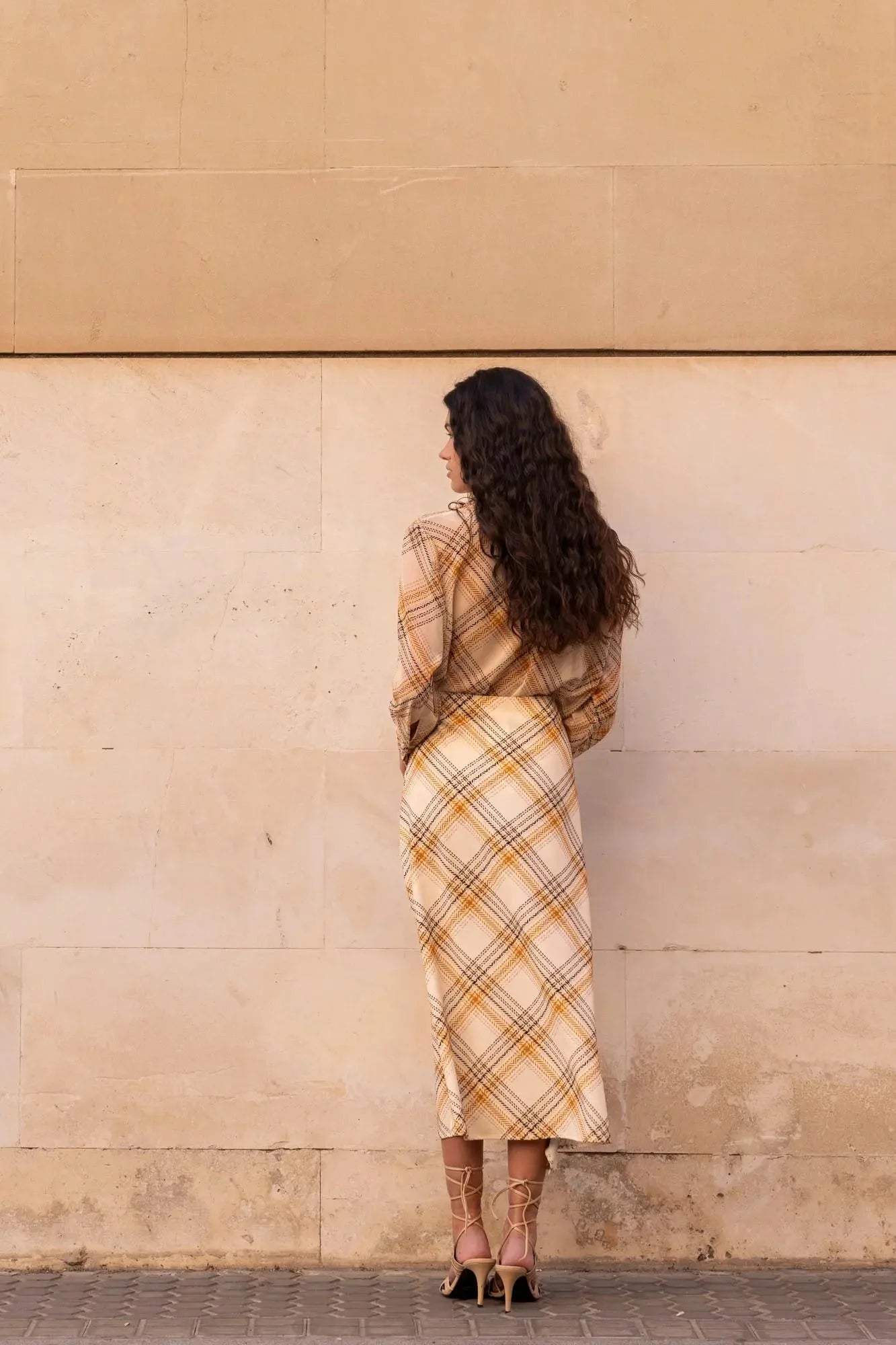 Femme portant une jupe midi à carreaux femme et chemise à carreaux, look élégant
