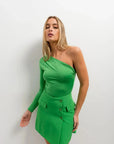 Femme portant une mini jupe asymétrique avec poche et top vert chic et tendance