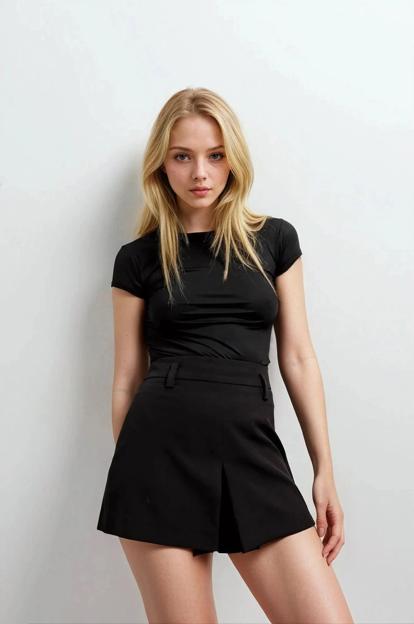 Femme portant une mini jupe avec fente en noir et un top noir courte