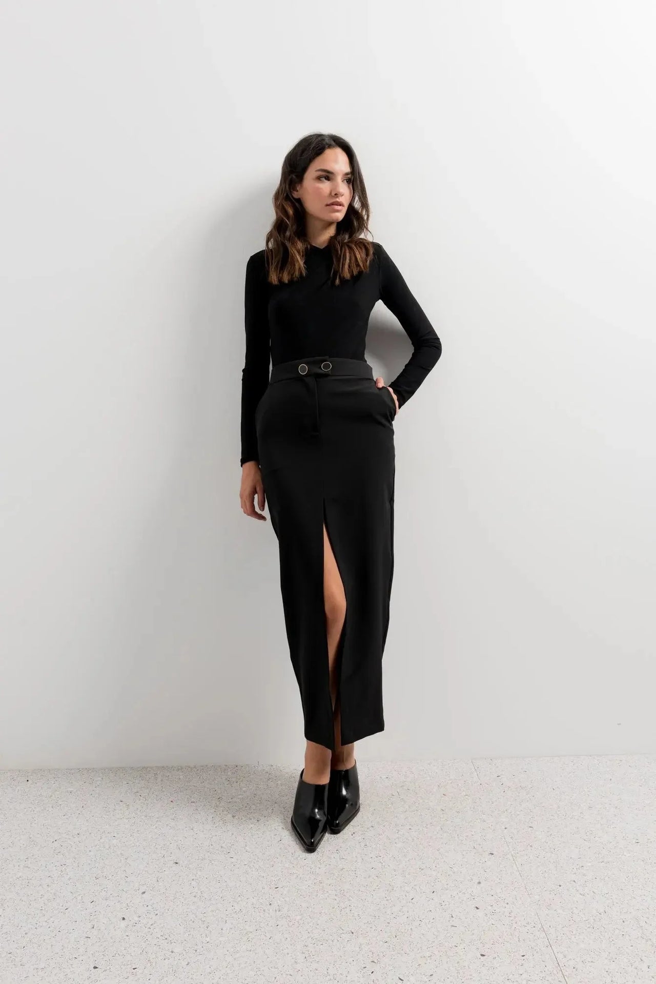 Femme en jupe longue fendue devant, modèle Jupe Boutonnée Midi Fendue Noir - Élégance Confortable Pour Toutes Occasions, affichant un style chic avec un haut noir.