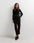 Femme en jupe longue fendue devant, modèle Jupe Boutonnée Midi Fendue Noir - Élégance Confortable Pour Toutes Occasions, affichant un style chic avec un haut noir.