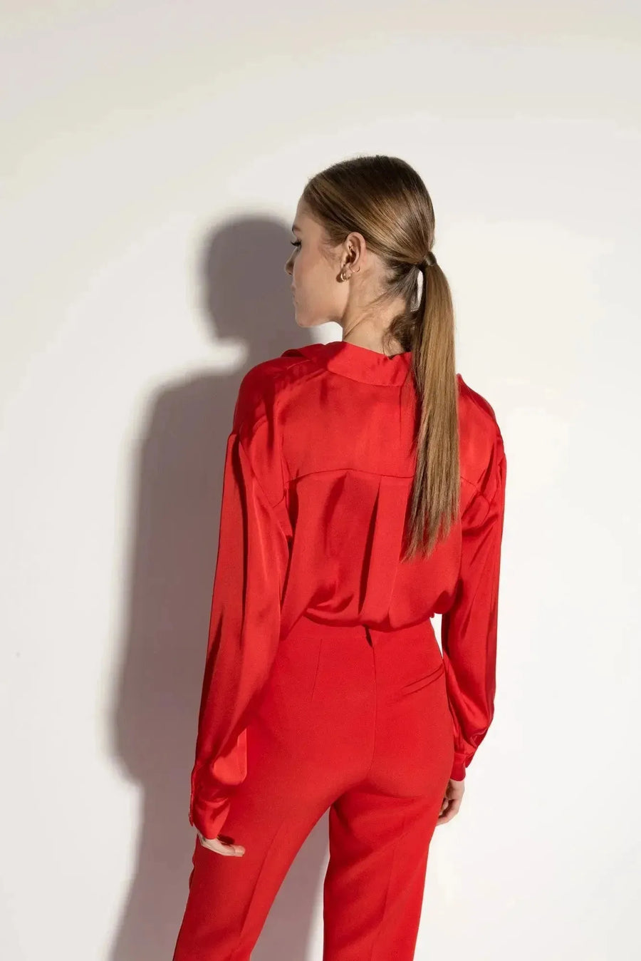 Pantalon Satin Rouge à Ourlets Fendus – Confort Élégant avec Poches et Taille Élastique, vue arrière d'un mannequin soulignant la coupe moderne, parfait pour un pantalon féminin polyvalent.