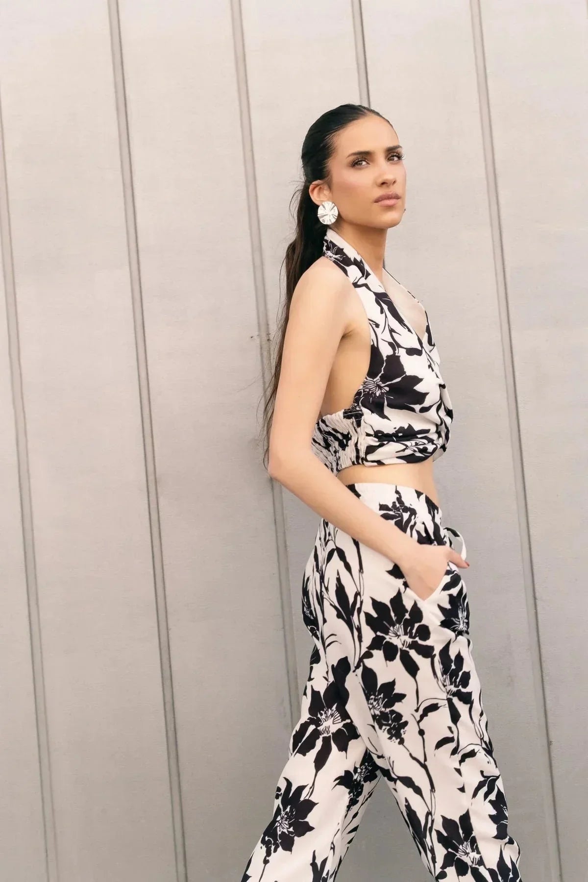 Femme portant un ensemble pantalon fluide imprimé floral et haut licou en mode élégant