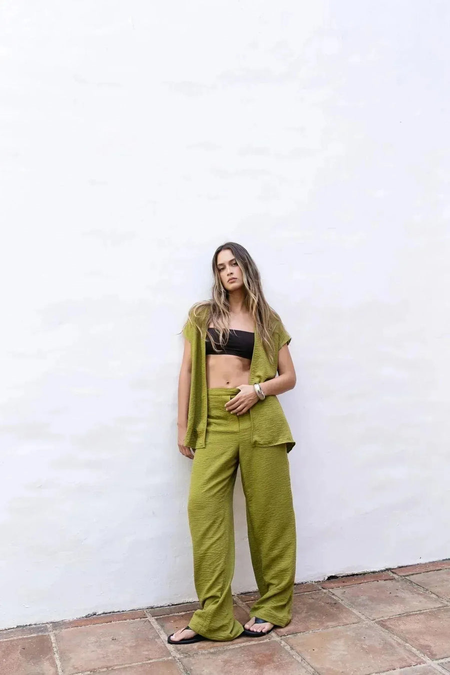 Modèle debout en pantalon fluide vert olive femme avec un haut assorti, alliant confort et style pour l'été.
