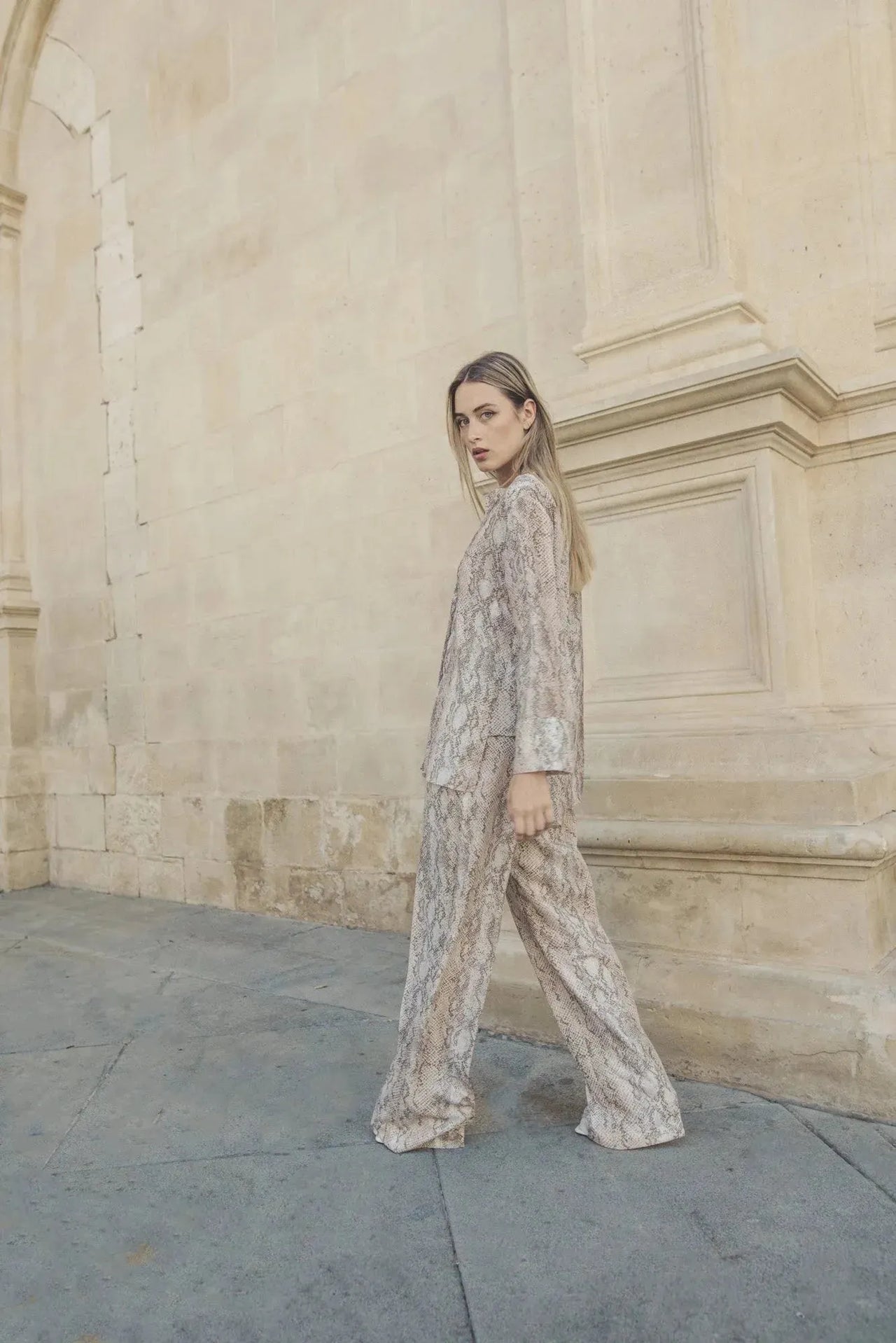 Mode féminine avec un pantalon serpent, la mannequin affiche un look élégant avec un ensemble pantalon large imprimé animal serpent.