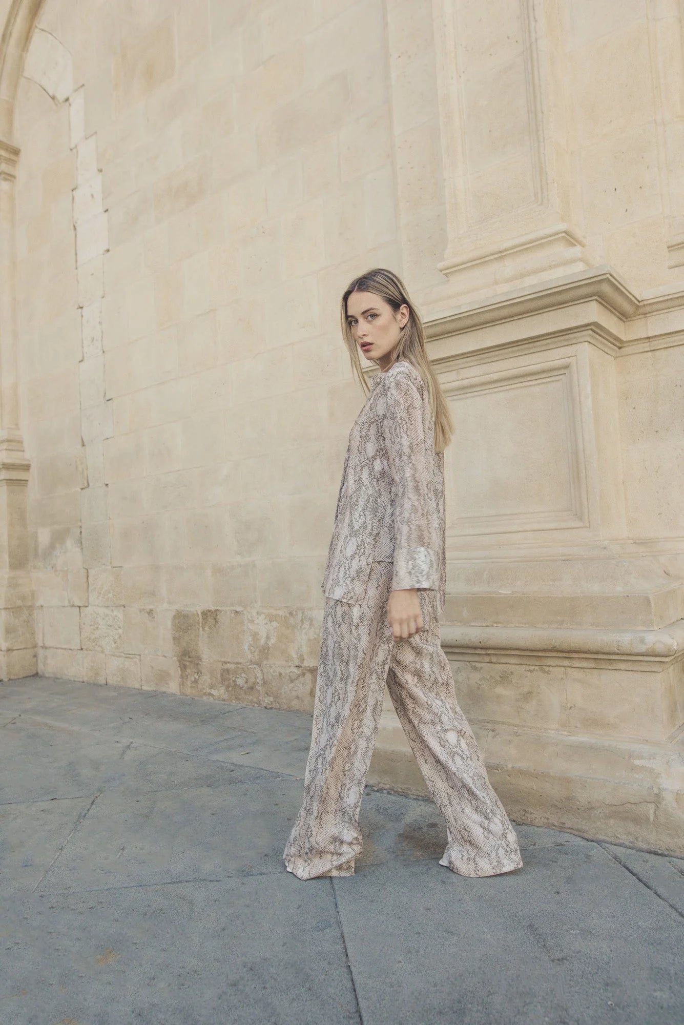 Femme portant un ensemble pantalon imprimé animal serpent avec blazer à imprimé animal