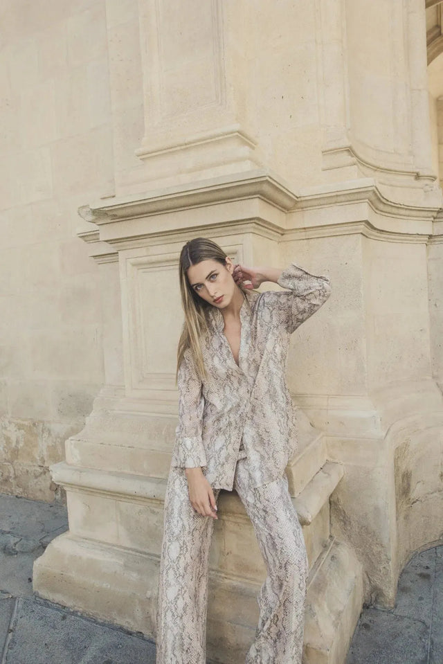 Femme posant avec style en tenue coordonnée composée d'un pantalon large serpent, mettant en avant l'ensemble pantalon large imprimé animal serpent.