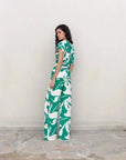 Femme vue de dos dans un ensemble pantalon palazzo imprimé floral vert et blanc, illustrant le pantalon palazzo femme avec un design original.